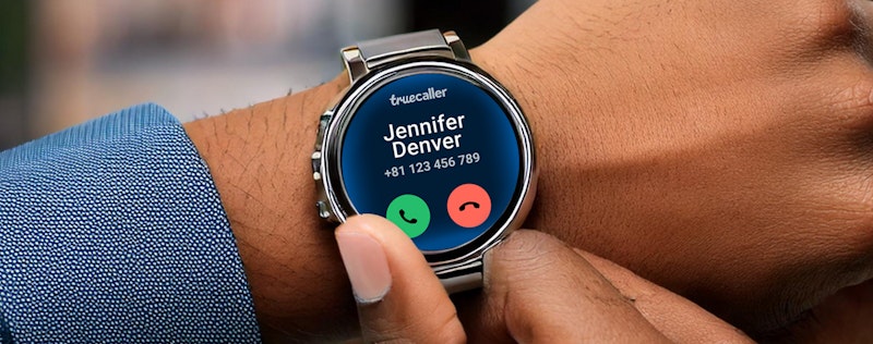 Image with a person with a smartwatch on their wrist showing an incoming call from Truecaller